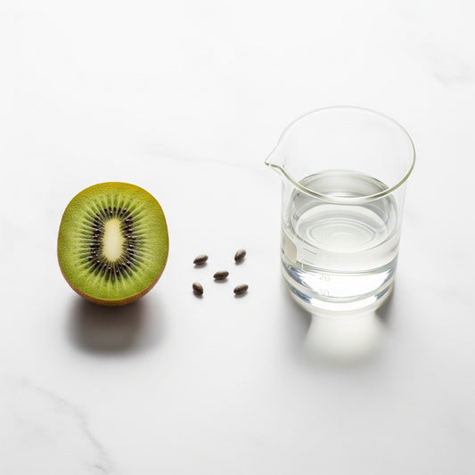A minimalist still life showing the key ingredients of a natural beard oil: a vibrant green kiwifruit and pure olive squalane in a lab beaker.