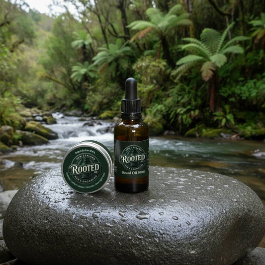 Rooted Beard Butter and Beard Oil duo on a river stone with natural forest background